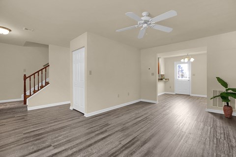 a living room with white walls and a ceiling fan