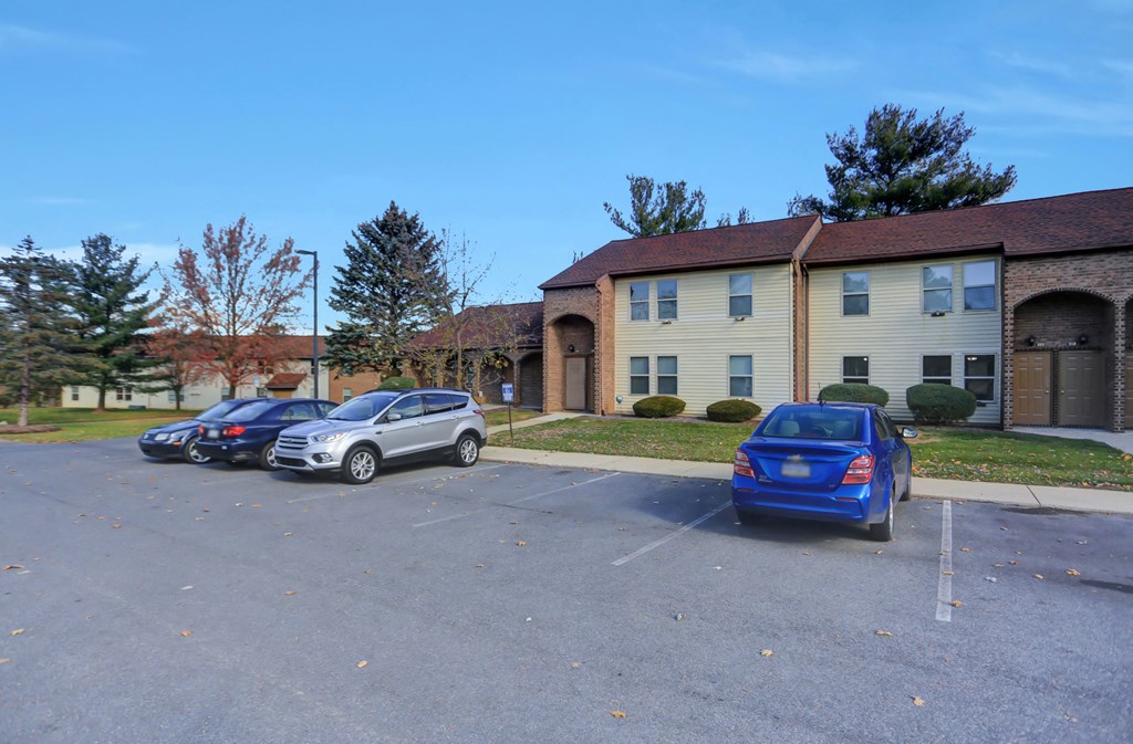 a parking lot with cars in front of a building