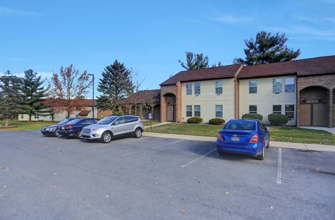 a parking lot with cars in front of a building