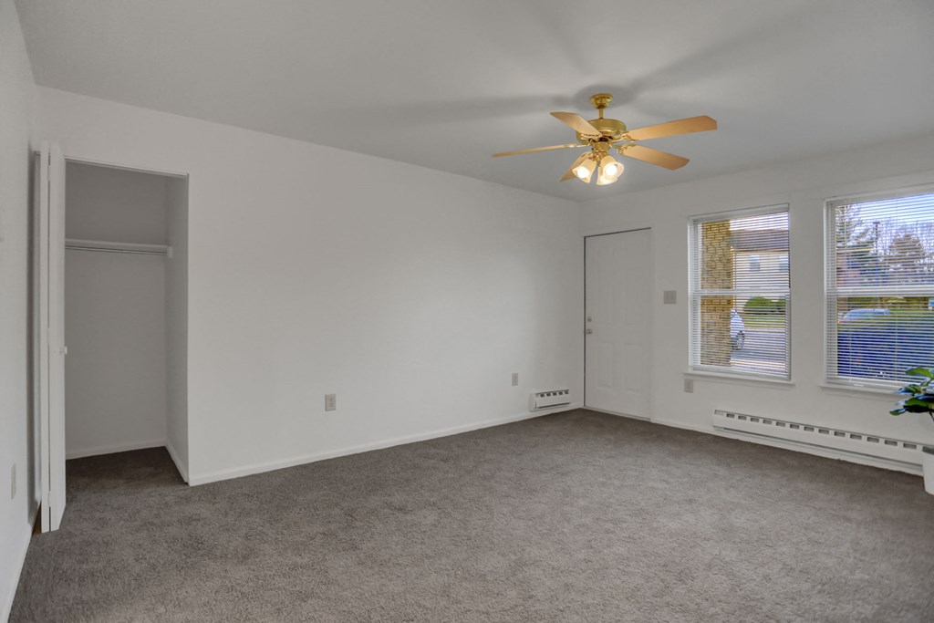 the living room of an empty home with a ceiling fan
