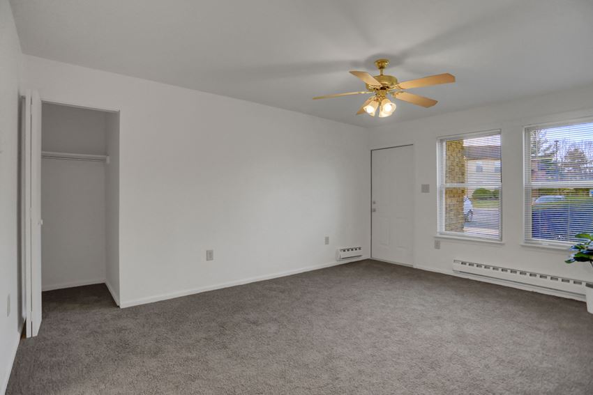 a bedroom with a ceiling fan and three windows