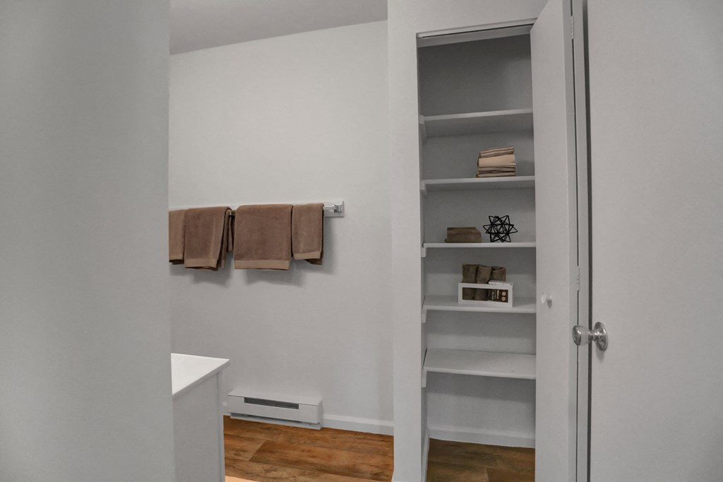 a small bathroom with a closet and towels hanging on the wall