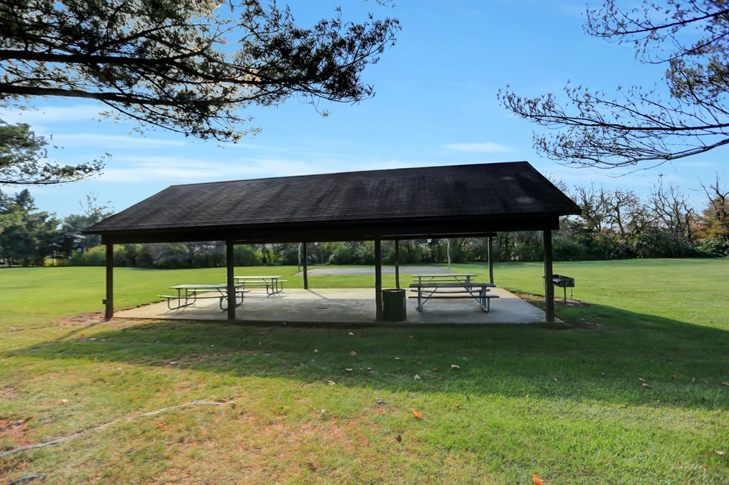 a pavilion with benches in the middle of a field