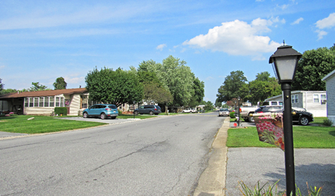a street in a neighborhood with houses and cars parked on the side of the road