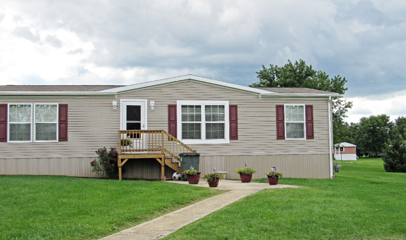 A house with a grey siding and red window frames.