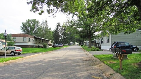 a street with houses and cars parked on the side of the road