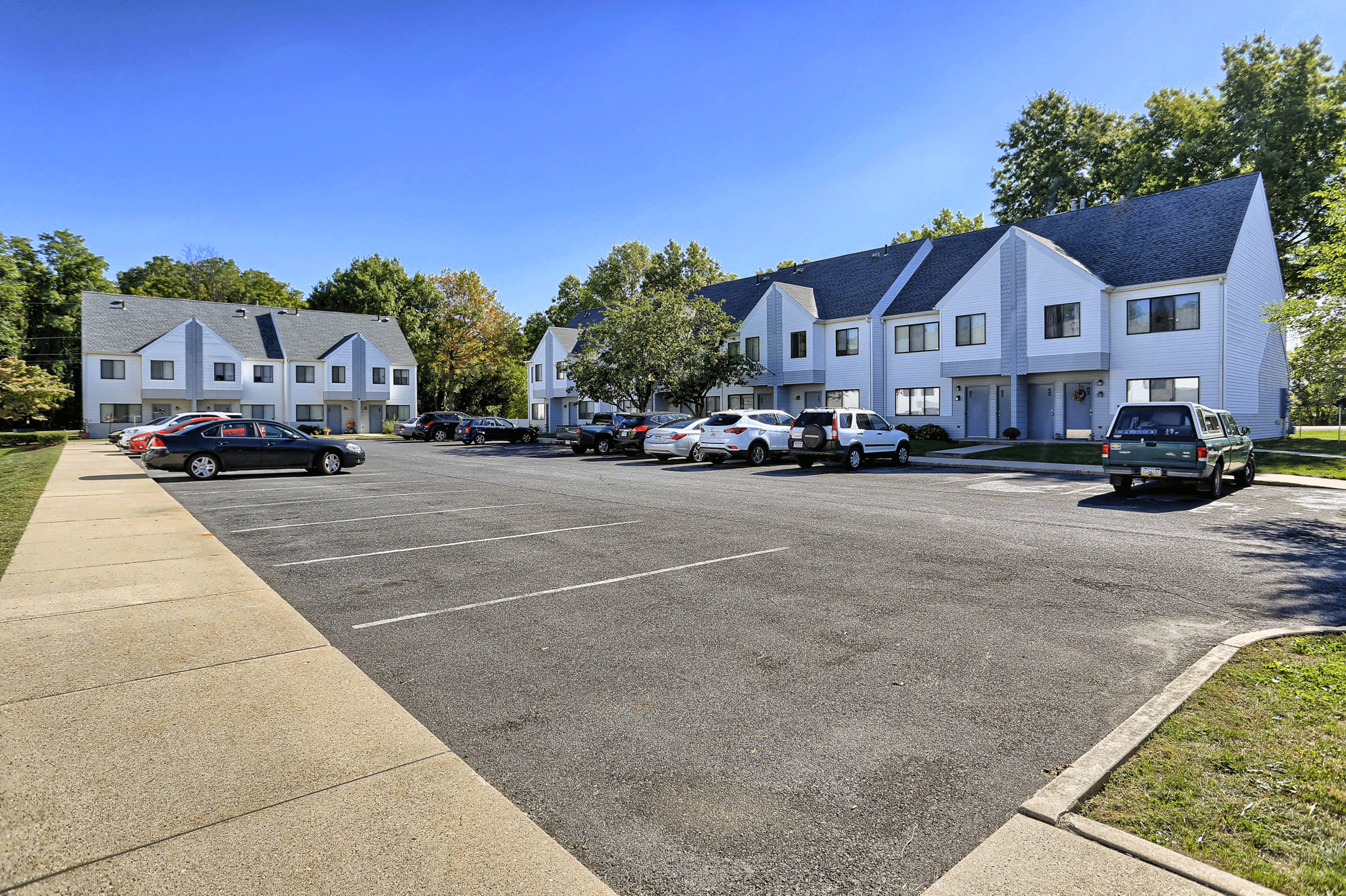 a parking lot with cars parked in front of houses
