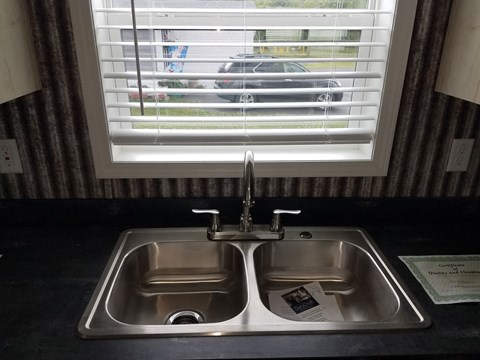 A kitchen sink with a window in the background.