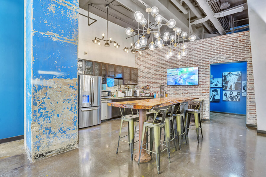 Conference table with kitchen and coffee machine, concrete floor and beautiful historic blue wall
