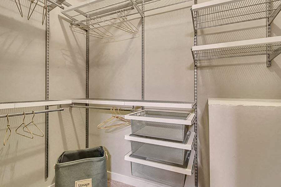 Large walk-in closet with custom shelves and drawers