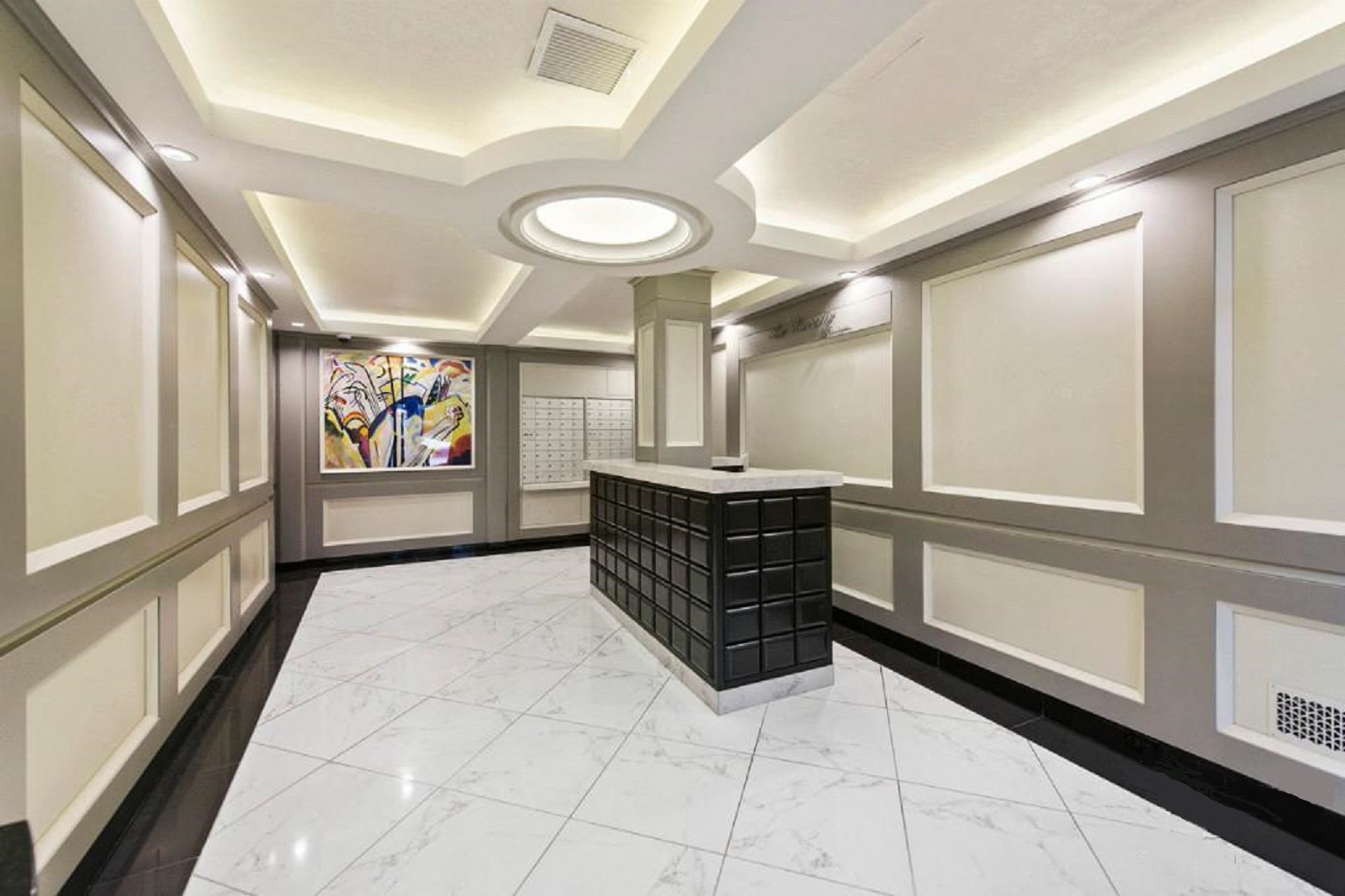 the lobby of a building with a counter and a painting on the wall