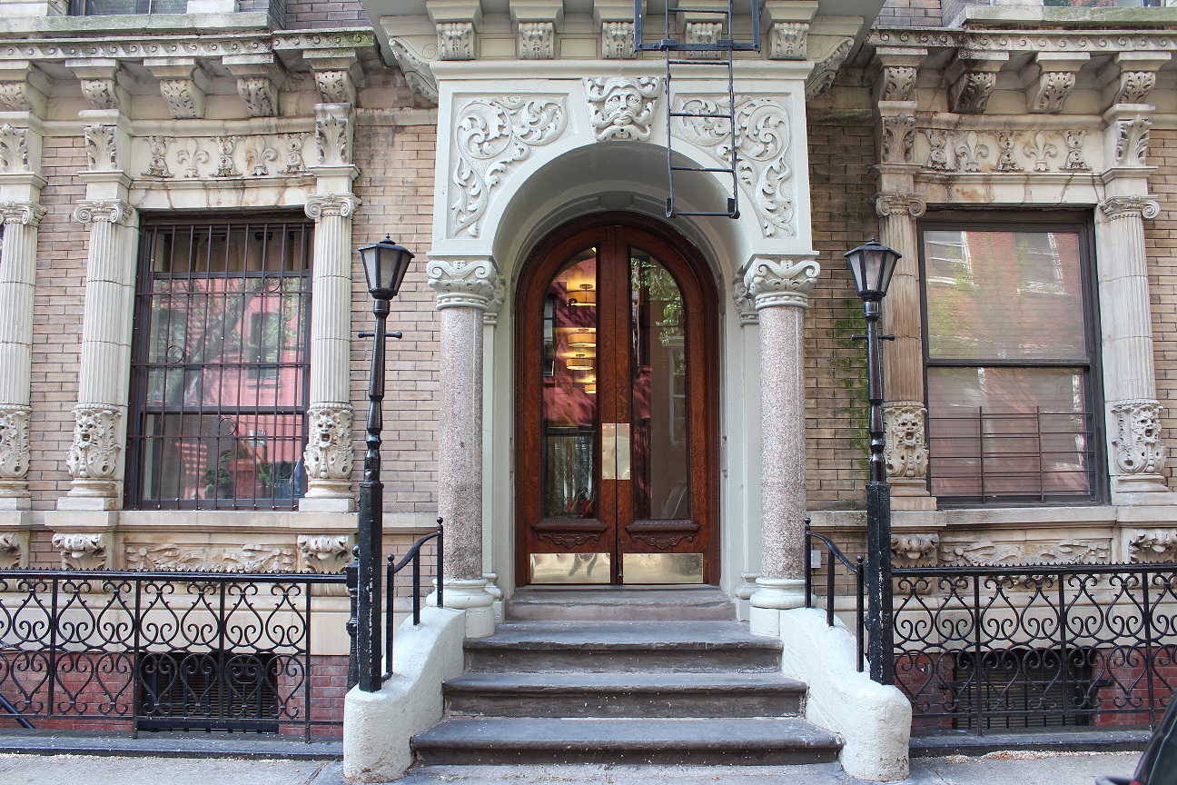 the front of a building with a door and stairs
