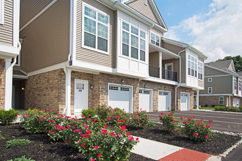 an exterior view of an apartment building with pink flowers