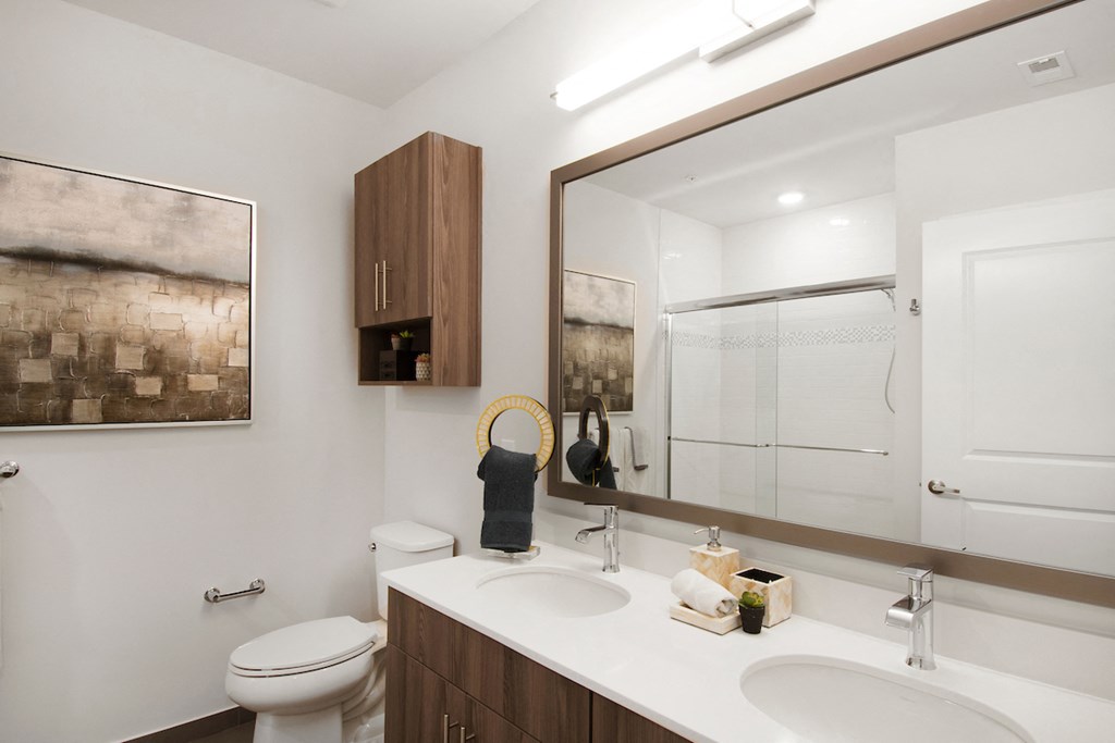 a bathroom with a large mirror and a toilet and sink