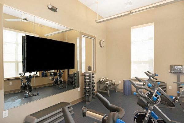 a gym with weights and a tv on the wall