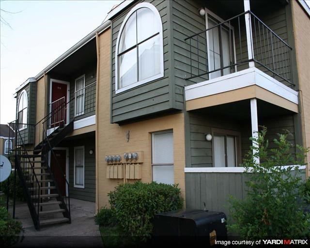 a green house with a balcony and a staircase