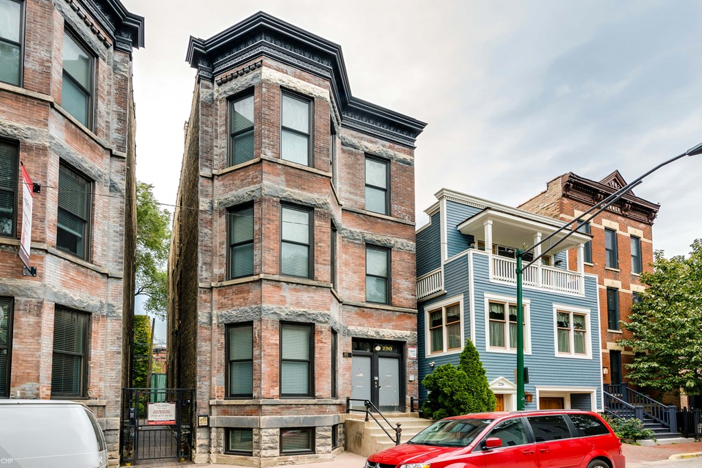 a red car parked in front of a brick building