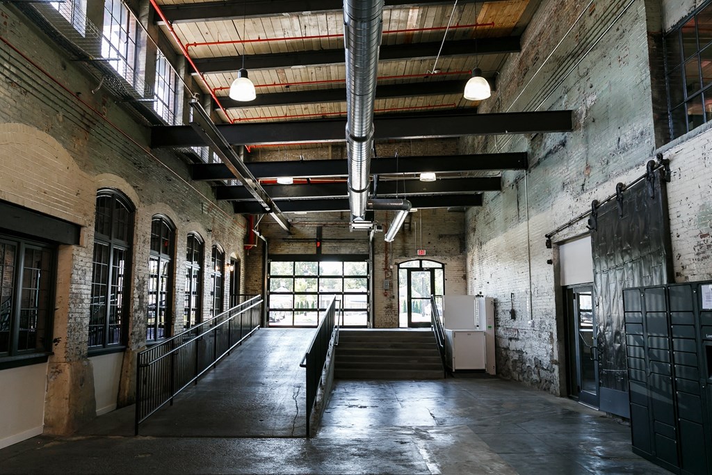the lobby of the building is empty and there is a staircase and windows