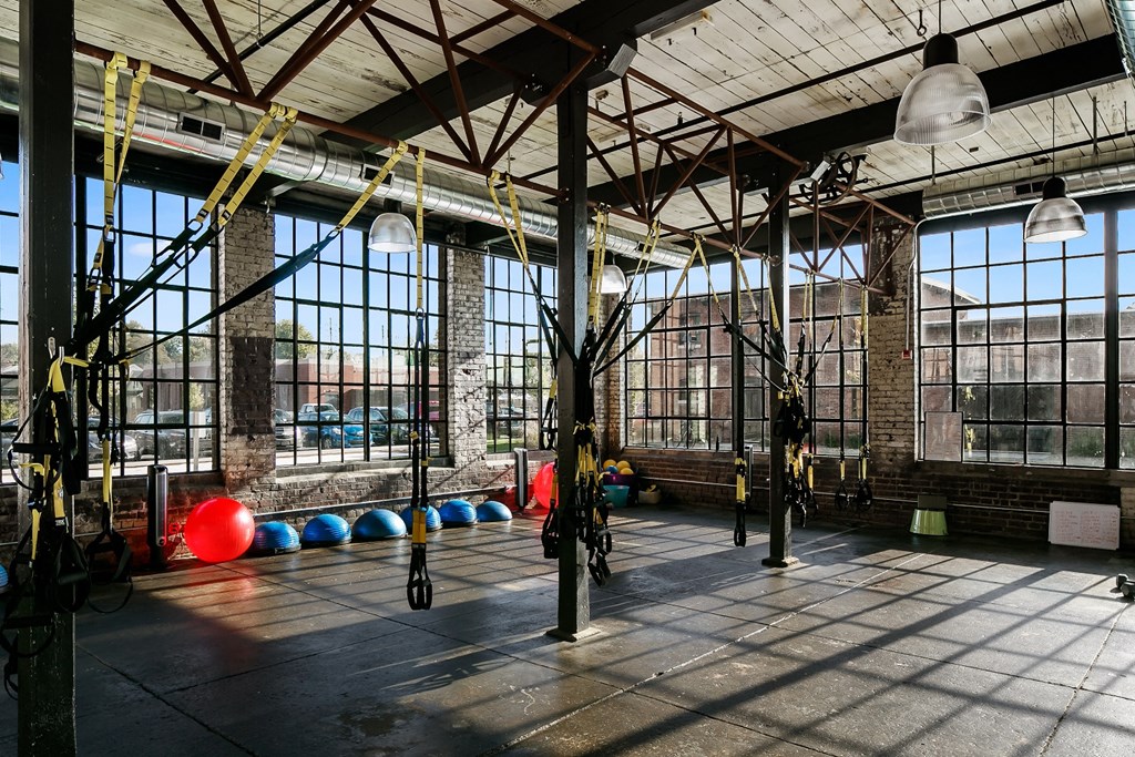 a gym with exercise equipment and windows in a building
