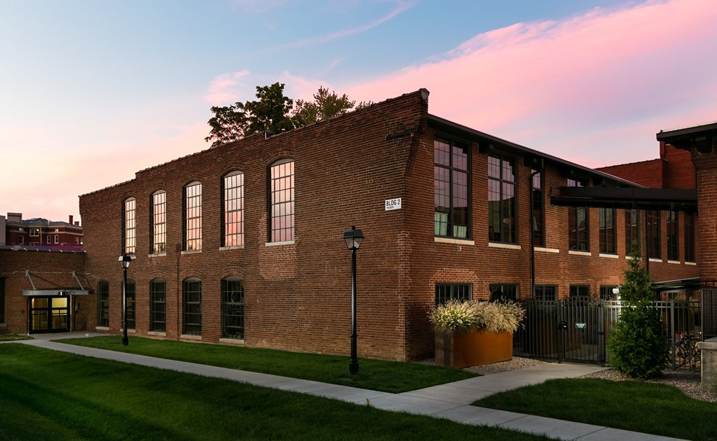 a red brick building with a sunset in the background
