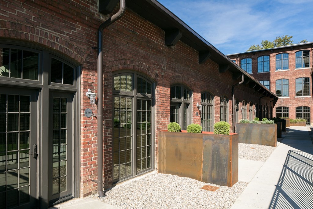 the side of a brick building with windows and a courtyard