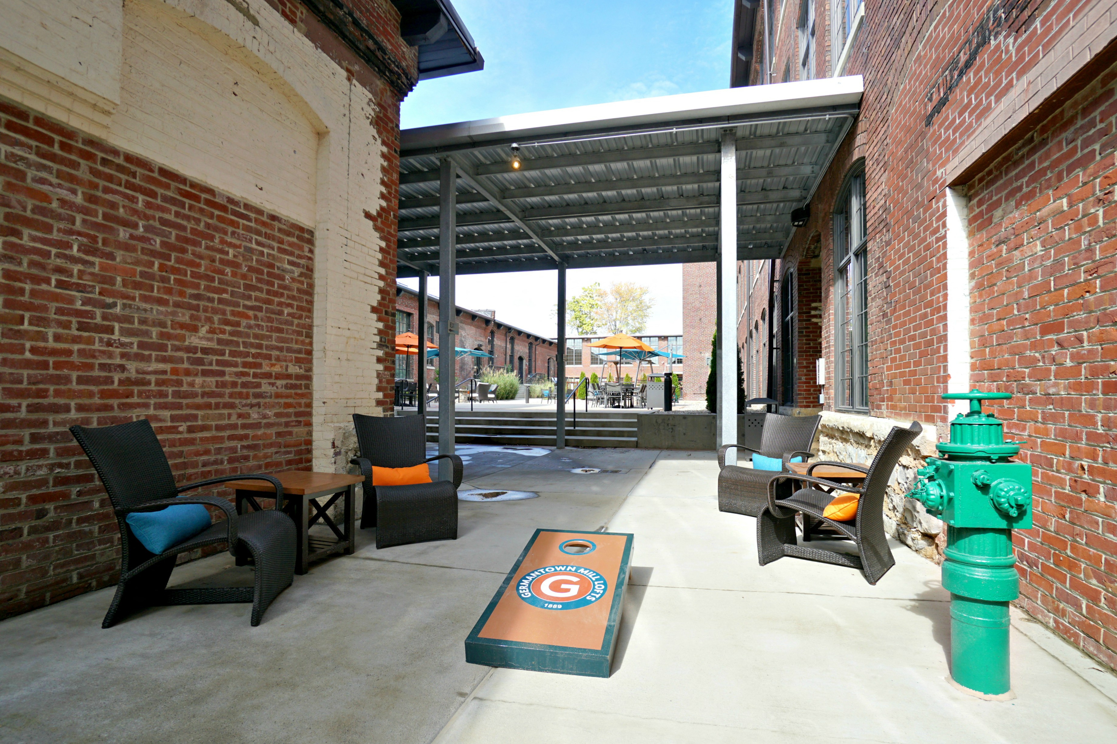 a patio with chairs and a green fire hydrant