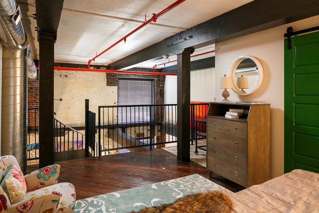 a living room with a couch and a dresser and a balcony