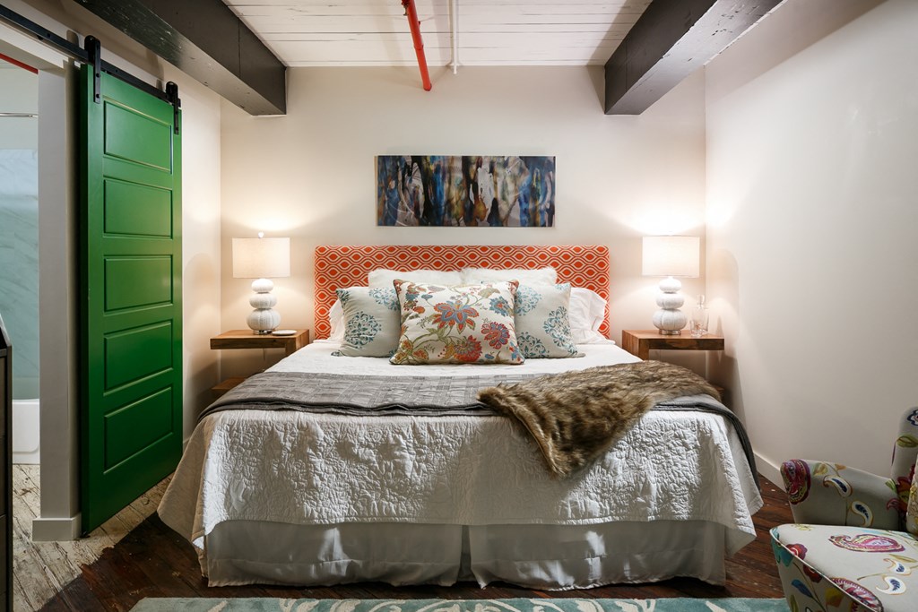 a bedroom with a bed and a green door