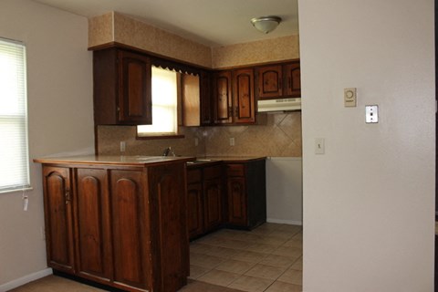 A kitchen with brown cabinets and a counter.