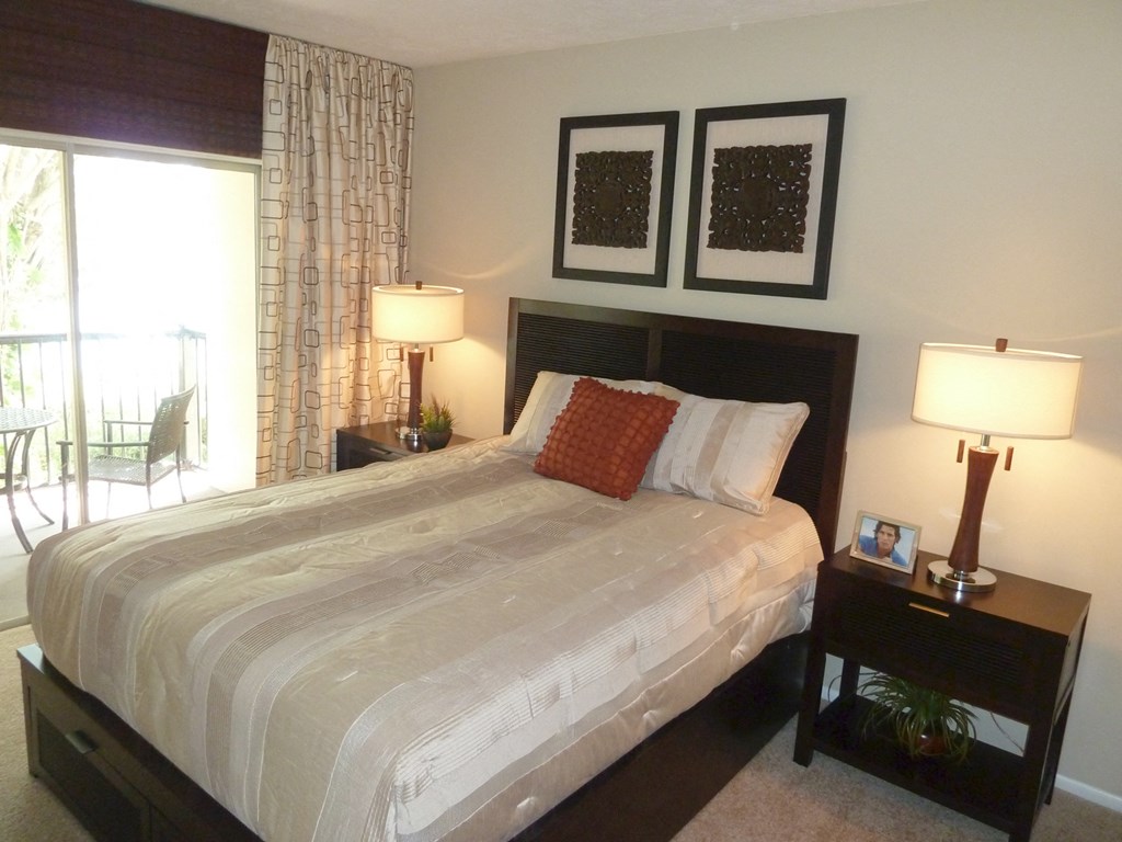 a bedroom with a bed and two lamps and a window