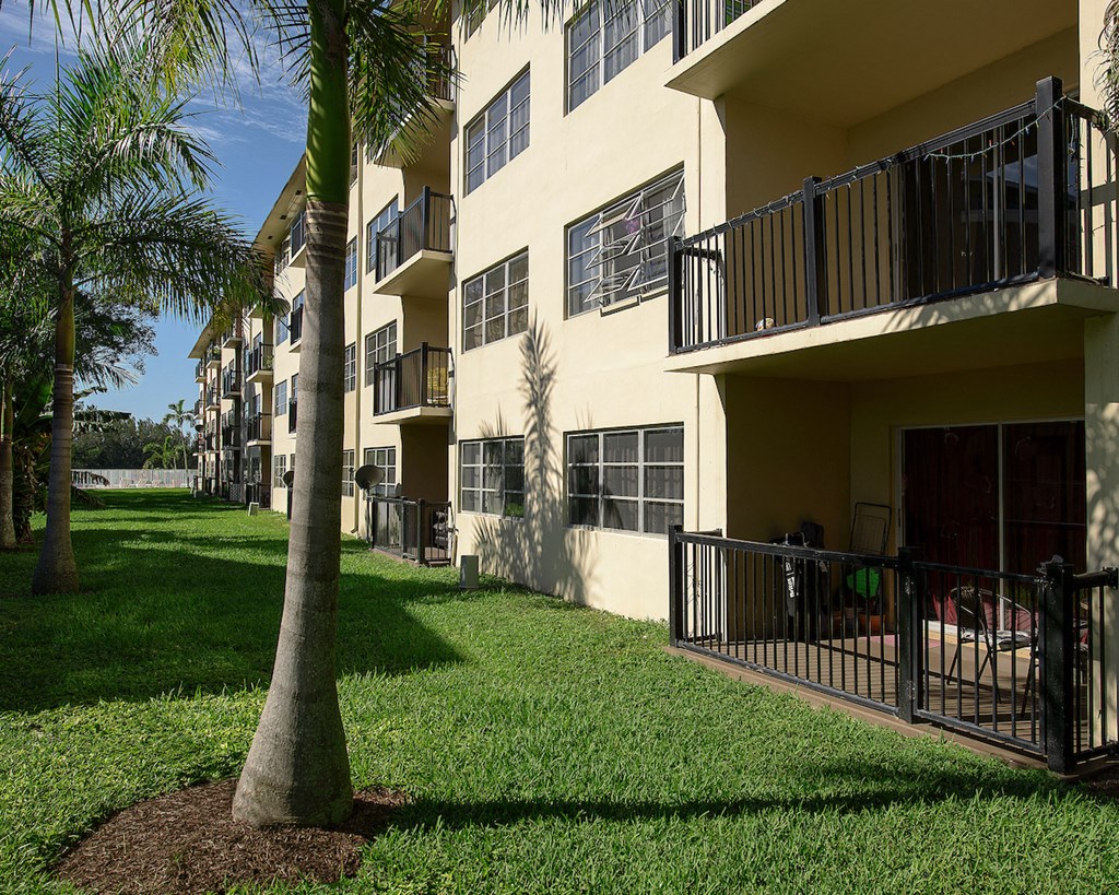 a building with balconies and palm trees in front of it