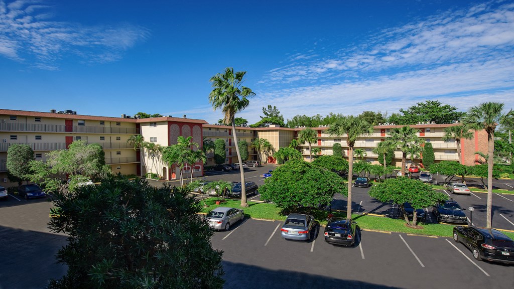 an aerial view of an apartment complex with cars parked in a parking lot