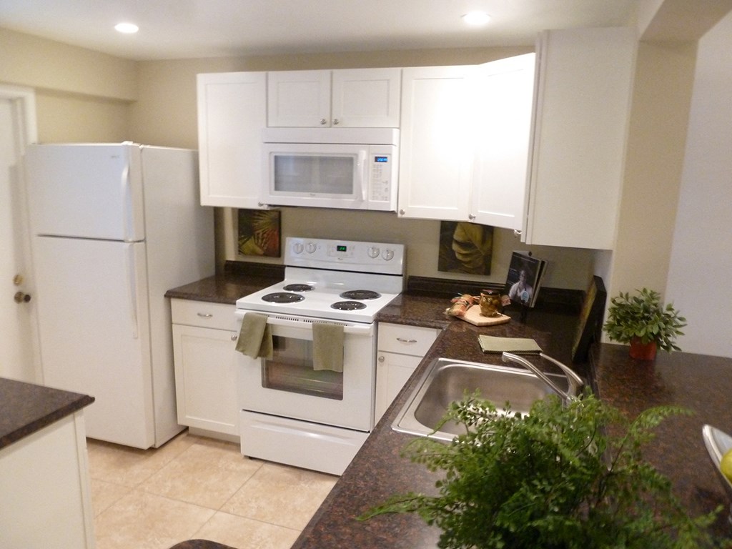a kitchen with white appliances and counter tops and a sink