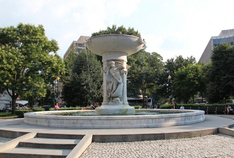 a fountain with a statue in a park