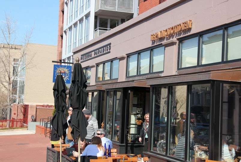 people sitting at tables outside of a restaurant