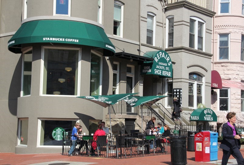 people walking past a starbucks coffee shop on a city street