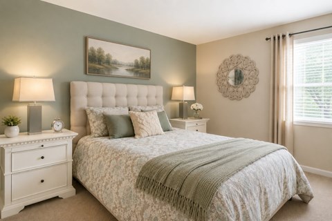 A bedroom with a large bed and a painting on the wall.