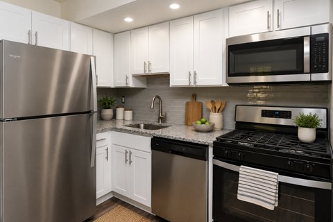 A modern kitchen with a stainless steel refrigerator and black oven.