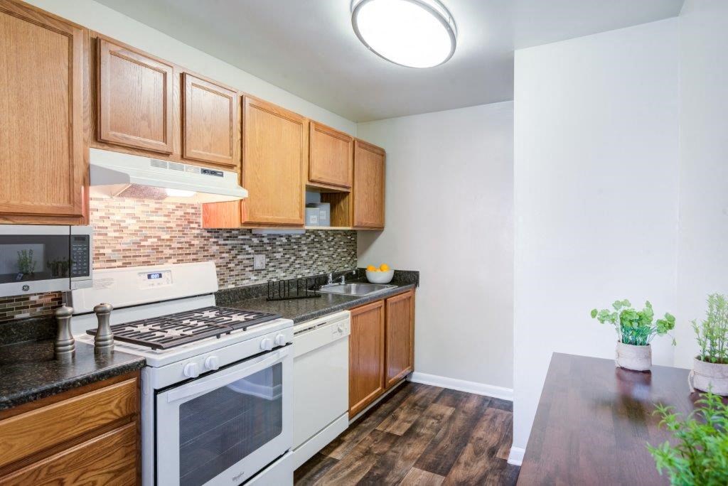 a kitchen with wooden cabinets and a stove top oven