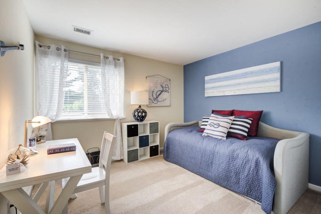 a bedroom with a bed and a desk and a chair