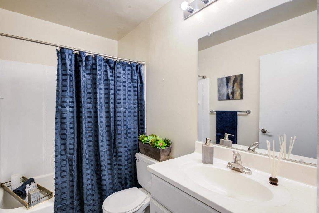 a bathroom with a blue shower curtain and a white sink