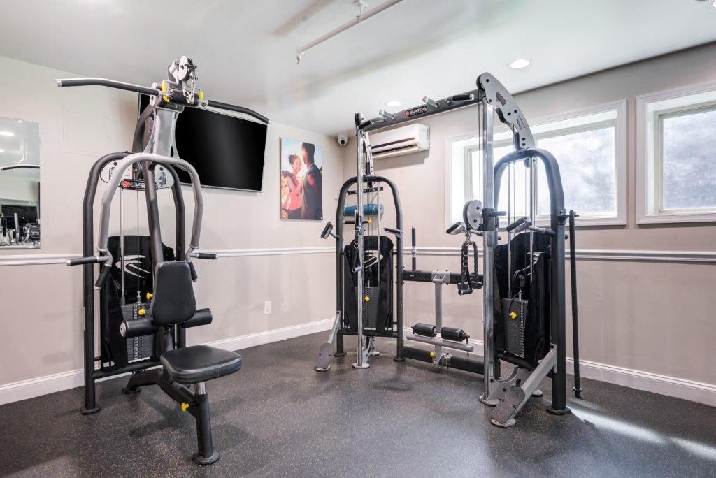 a home gym with weights and a tv