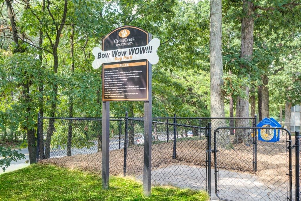 a park with a sign in front of a chain link fence