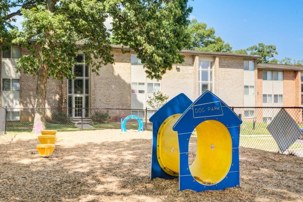 a playground in front of an apartment building with two blue and yellow portable toilets