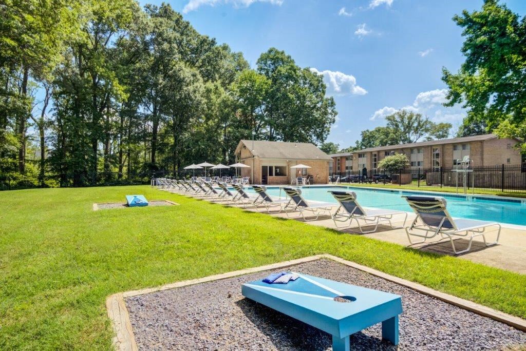 a swimming pool with chaise lounge chairs and a blue table