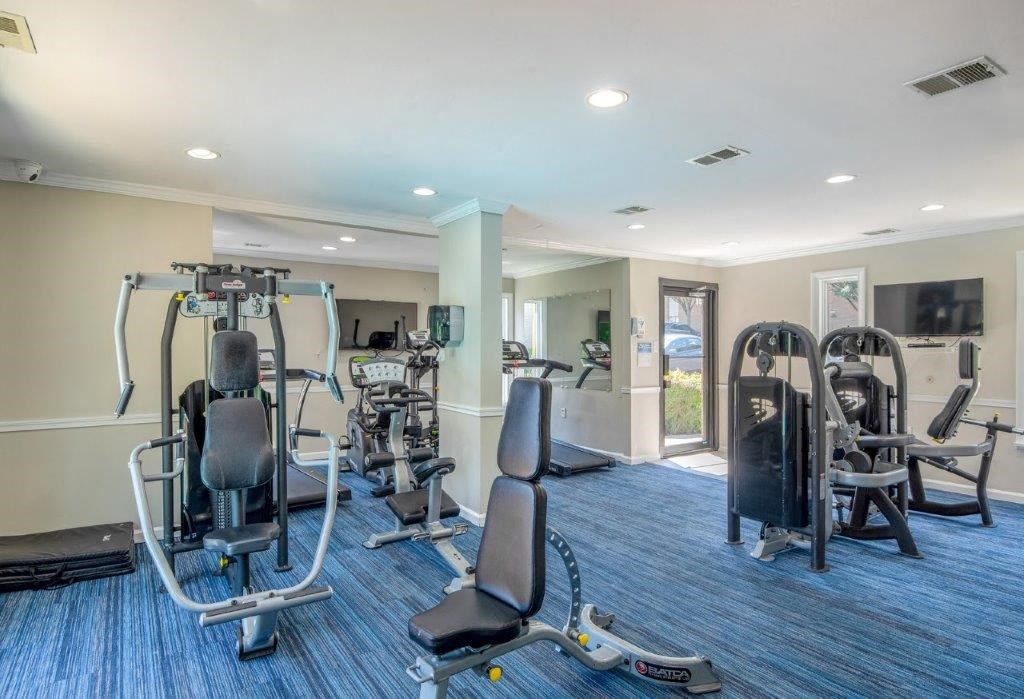 a gym with weights and cardio equipment in a building