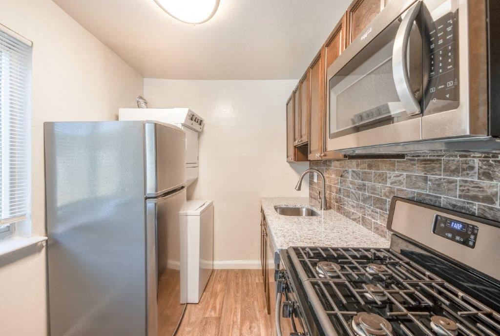 a kitchen with a stove refrigerator and microwave