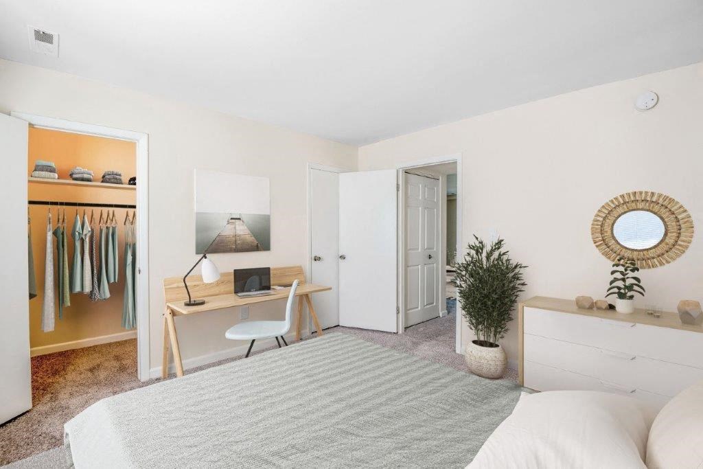 a bedroom with a bed and a desk and a closet