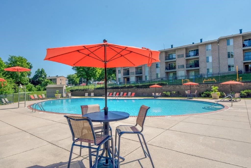 our apartments have a pool and patio with chairs and umbrellas
