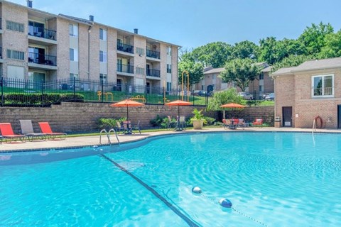 a large swimming pool with an apartment building in the background